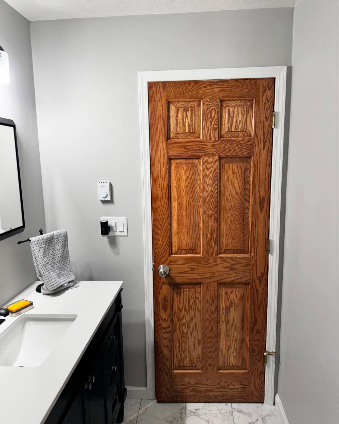 New wood door and tile flooring in remodeled bathroom